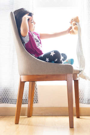 Cute little girl playing with her teddy bearの写真素材