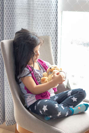 Cute little girl playing with her teddy bearの写真素材