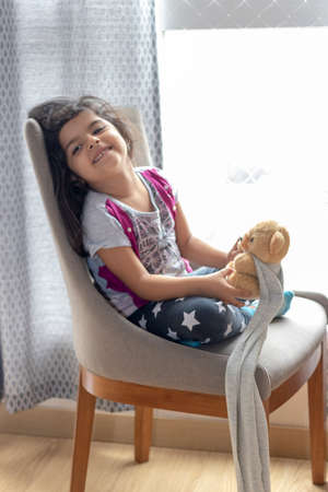 Cute little girl playing with her teddy bearの写真素材