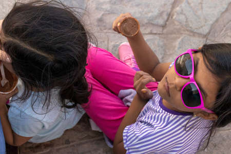 Cute little girl with sunglasses eating a delicious ice creamの写真素材