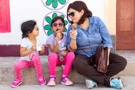 Mother with her daughters eating ice creamの写真素材