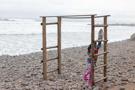Cute little girl with colorful sweater playing on the beachの写真素材