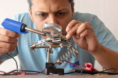 Electronic technician working on the repair of a cardの写真素材