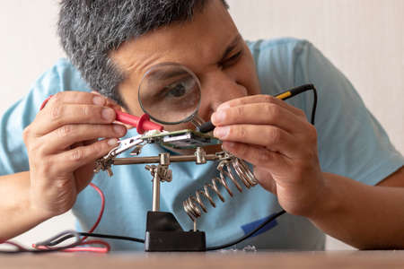 Electronic technician working on the repair of a cardの写真素材