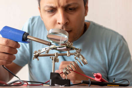Electronic technician working on the repair of a cardの写真素材