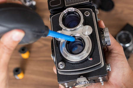 Performing cleaning of vintage photo cameraの写真素材