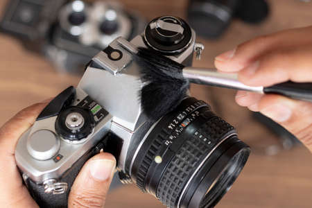 Performing cleaning of vintage photo cameraの写真素材