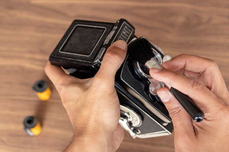 Performing cleaning of vintage photo cameraの写真素材