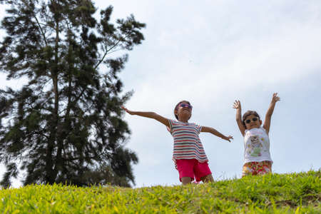 Cheerful girls, playing together in the parkの写真素材