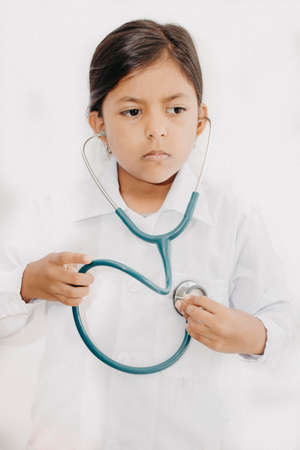 Cute little girl doctor, with stethoscope and white medical uniformの写真素材