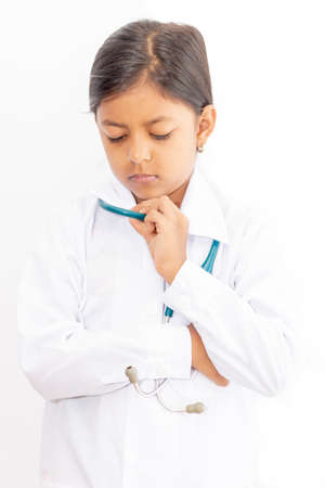 Cute little girl doctor, with stethoscope and white medical uniformの写真素材