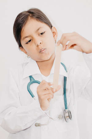 Cute little girl doctor, with stethoscope and white medical uniformの写真素材