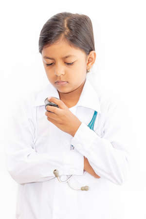 Cute little girl doctor, with stethoscope and white medical uniform