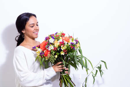 Cute brunette woman enjoying her bouquet of flowersの写真素材