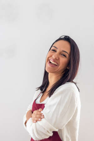 Cute smiling brunette with her apron placedの写真素材