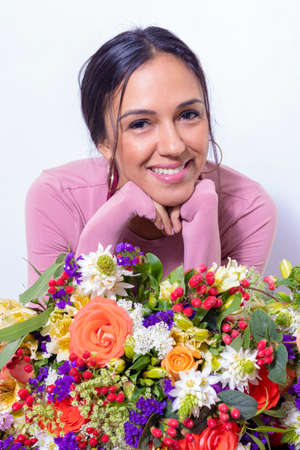 Cute brunette woman enjoying her bouquet of flowersの写真素材