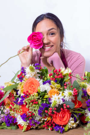 Cute brunette woman enjoying her bouquet of flowersの写真素材