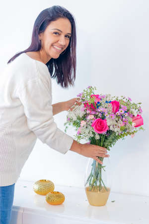 Cute brunette woman enjoying her bouquet of flowersの写真素材