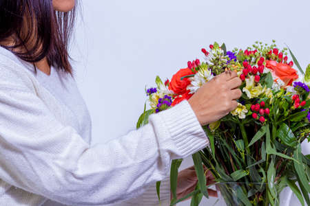 Woman's hand decorating floral arrangementの写真素材
