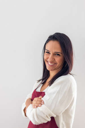 Cute smiling brunette with her apron placedの写真素材