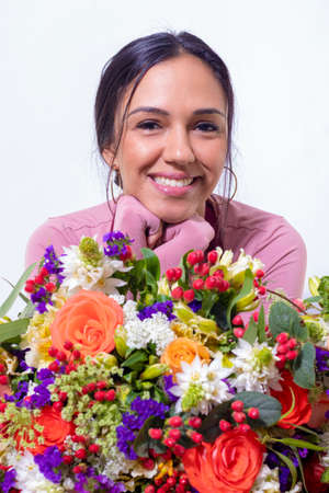 Cute brunette woman enjoying her bouquet of flowersの写真素材