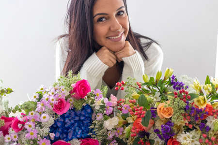 Cute brunette woman enjoying her bouquet of flowersの写真素材