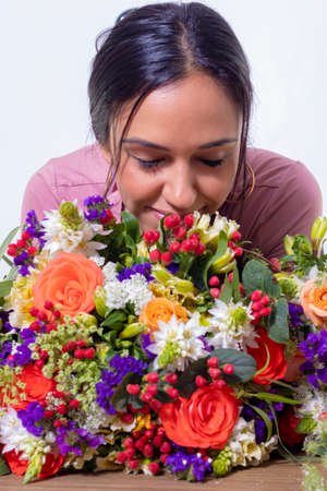 Cute brunette woman enjoying her bouquet of flowersの写真素材