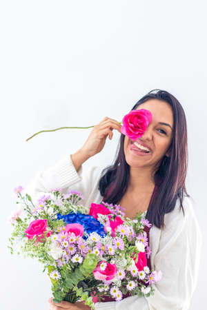 Cute brunette woman enjoying her bouquet of flowersの写真素材
