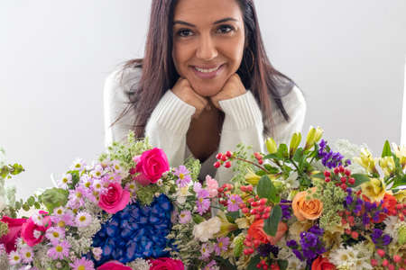Cute brunette woman enjoying her bouquet of flowersの写真素材