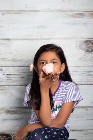 Cute brunette girl playing with pink rosesの写真素材