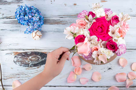 Florist preparing a bouquet of pink and red rosesの写真素材