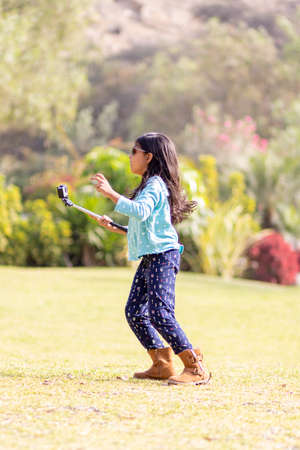 Little girl taking a picture with an action cameraの写真素材