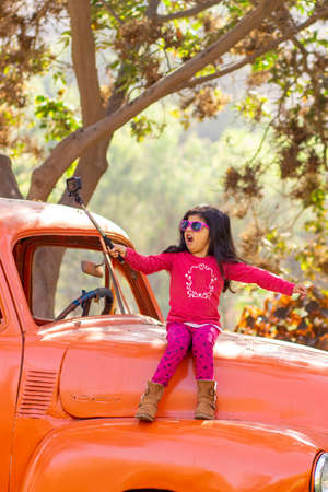 Little girl taking a picture with an action cameraの写真素材