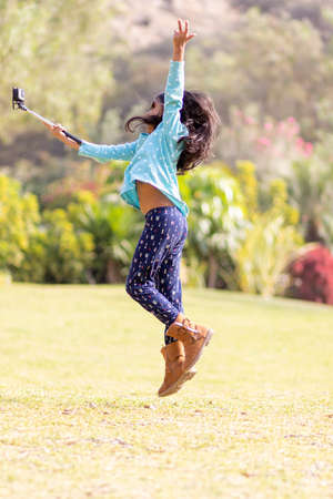 Little girl taking a picture with an action cameraの写真素材