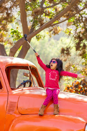 Little girl taking a picture with an action cameraの写真素材