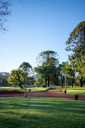 View of a beautiful park with green areas and reddish soil, located within the cityの写真素材