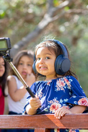 Little girl taking a picture with an action cameraの写真素材