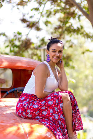Cute latin woman posing on an orange carの写真素材