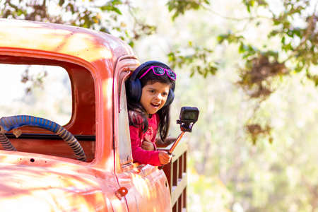 Little girl taking a picture with an action cameraの写真素材