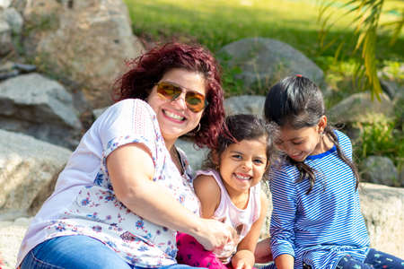 Cute family of mother and daughters in the gardenの写真素材