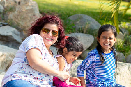 Cute family of mother and daughters in the gardenの写真素材