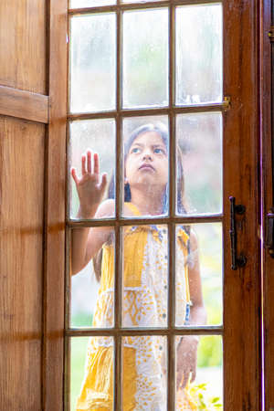 Brunette girl behind wooden and glass doorの写真素材