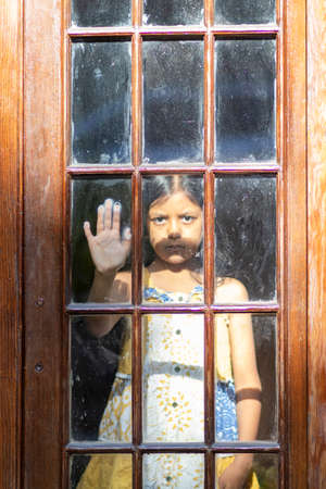 Brunette girl behind wooden and glass door