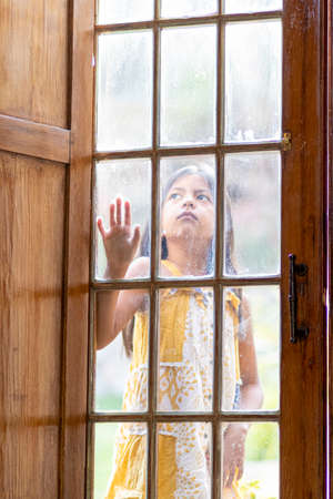 Brunette girl behind wooden and glass doorの写真素材
