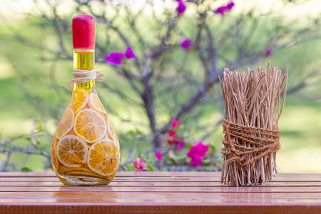 Pickled orange slices in glass bottle, on wooden table