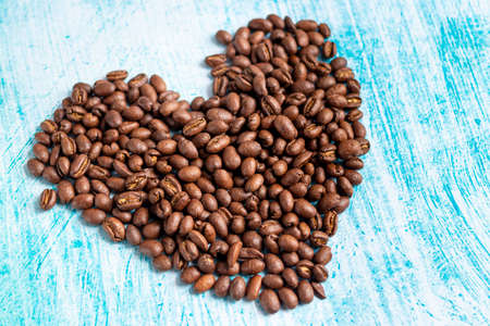 Heart shaped coffee grains on aquamarine backgroundの写真素材