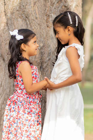 Tender little sisters hugging each other and showing their true loveの写真素材