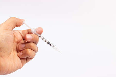 Hand holding an insulin syringe before being usedの写真素材