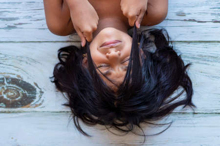 Close up of brunette teenager touching her face with her handsの写真素材