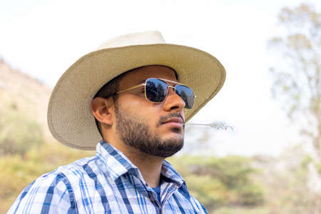 Young cowboy with dark glasses and looking at the horizonの写真素材